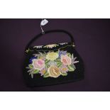 A vintage evening bag having beadwork ground with extensive floral embroidery and clasp top