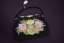 A vintage evening bag having beadwork ground with extensive floral embroidery and clasp top