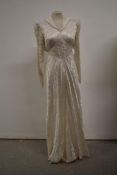 A 1930s wedding dress having collar and long sleeves and tie belt to waist, no fastening.