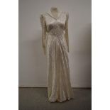 A 1930s wedding dress having collar and long sleeves and tie belt to waist, no fastening.