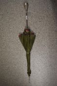 A 1950s umbrella having floral lining and olive green outer layer and ornate metal handle with