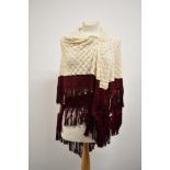 A late 19th/ early 20th century cream shawl having burgundy edging with fringing.