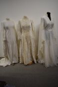 Three white maxi or wedding dresses, to include white velvet 1950s gown and two 1960s/70s dresses.