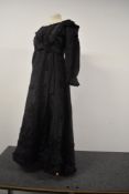 A late Victorian black silk dress having boned bodice, with fluted collar, sequin details to skirt