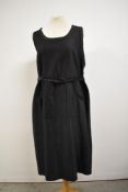 A 1920s black cotton chore dress or pinafore with pockets to front and belted waist, very good