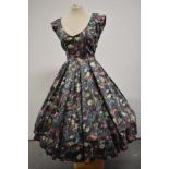 A 1950s floral polished cotton day dress having low scoop neckline and very full skirt.