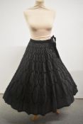 A late 1940s evening skirt having flocked black velvet pattern throughout and velvet ties to