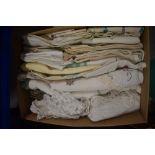 A box full of vintage and antique table linen including embroidered examples, tray and table