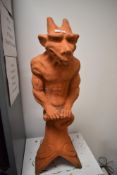 A late Victorian terracotta roof or ridge tile with a grotesque gargoyle figure perched atop