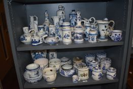 A large selection of Dutch Delft wares over two shelves including bowls, vases, planters,