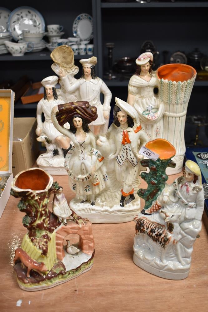 A selection of antique Staffordshire flat back figures and spill vases. All having age related wear,