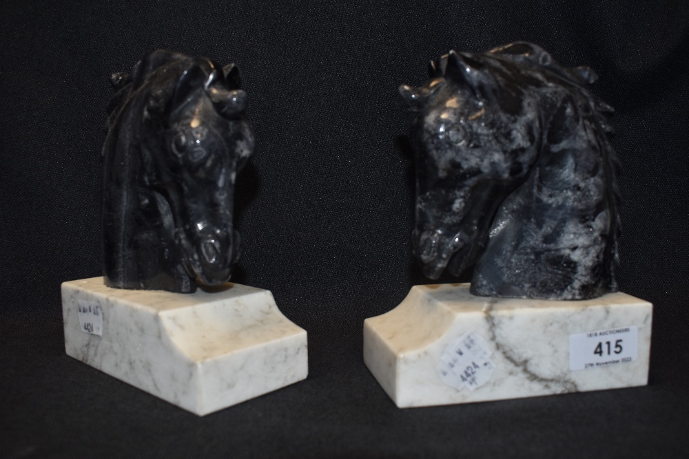 A pair of horse head book ends carved in black marble with white bases. 16 cm tall approx