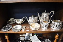 A selection of silver plated wares including chase worked tea set, gravy boat and chamber stick