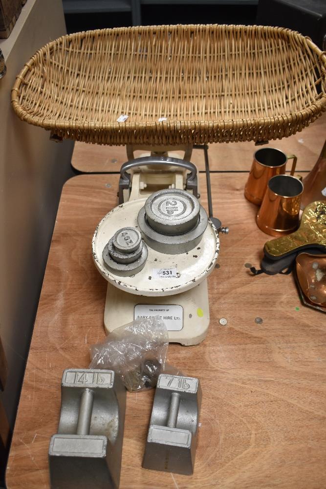 A set of mid century baby scales complete with basket 'The property of Baby scale hire ltd'.