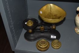 A set of early 20th century kitchen weighing scales with cast frame and brass pan with two weight