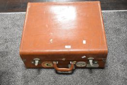 A vintage leather bound suitcase trunk with Aznar line and Wings badges.