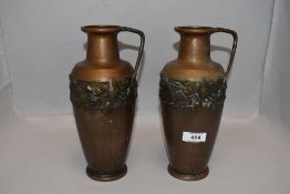 A pair of Arts and Crafts era Kaiser copper vases with brass effect ivy leaf decoration and handle