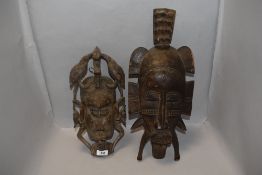 Two early 20th century African tribal wood carved masks in traditional designs, one possibly Fang