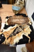 A Black sheep skin rug and two similar animal hide skins