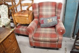 A modern armchair and footstool in tartan upholstery