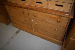 A natural pine low chest of three by three drawers
