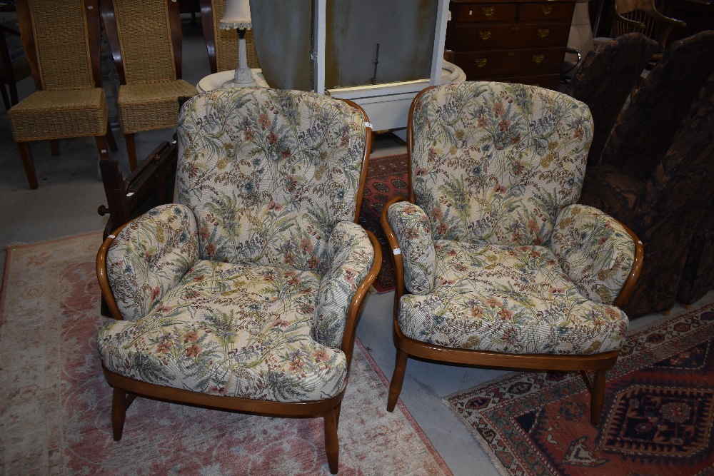 A pair of Ercol mid stain cottage arm chairs