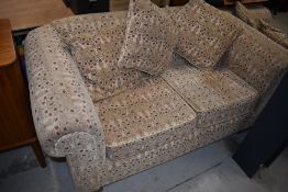 A modern settee in cream with maroon toned pattern