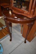 A reproduction demi lune side table