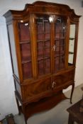 An Edwardian mahogany display cabinet having glazed section and cupboard under with cabriole legs