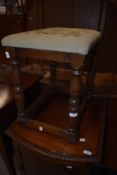 An oak stool with woolwork seat