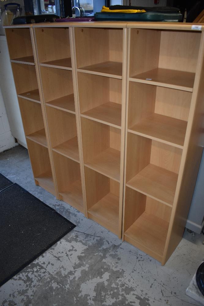 Four narrow laminate shelf units