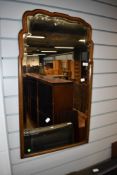 A late 19th or early 20th Century mahogany shaped wall mirror