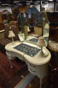 A painted kidney shaped dressing table on Queen Anne style legs with lamp fittings