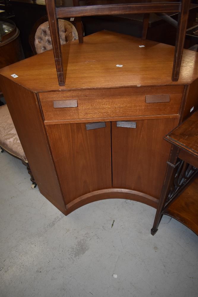 A teak G plan corner unit having drop flap drawer and concave cupboard base