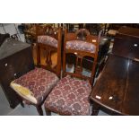 A pair of Victorian mahogany high back dining chairs having upholstered seats and shoulder rails