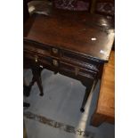 A period oak desk on cabriole legs having slope top and frieze drawer