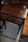 A period oak desk on cabriole legs having slope top and frieze drawer