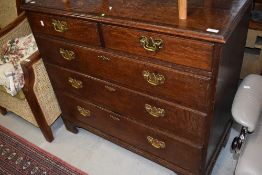 A Period oak chest of two over three drawers having brass drop handles and escutcheons and bracket