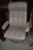 A vintage chrome and cream swivel easy chair with recline action