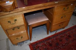 An Arts and Crafts style golden oak desk and similar stool
