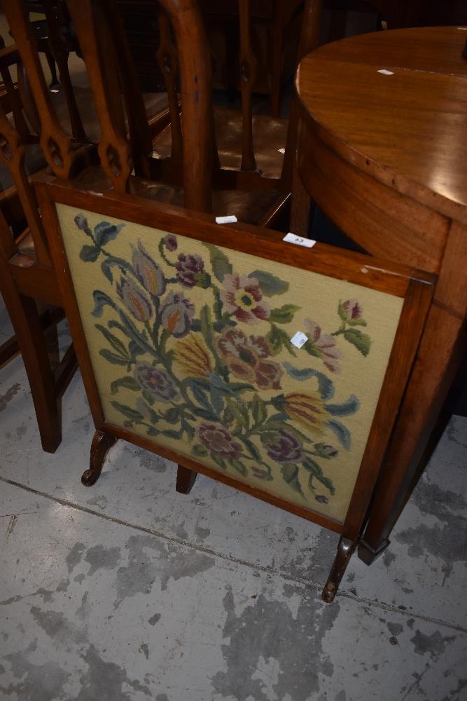 An early 20th Century stained frame fire screen having woolwork panel