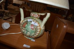 An Italian glazed pottery lamp , having three handle and painted mythical creature decoration