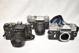 Three Zenit cameras. A Zenit TTL camera with Helios 44M lens, a Zenit E with Helios 44-2 lens, and a