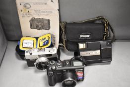 Three cameras. A Canon Powershot G5 digital camera with charger, cards and manual, a Konica C35