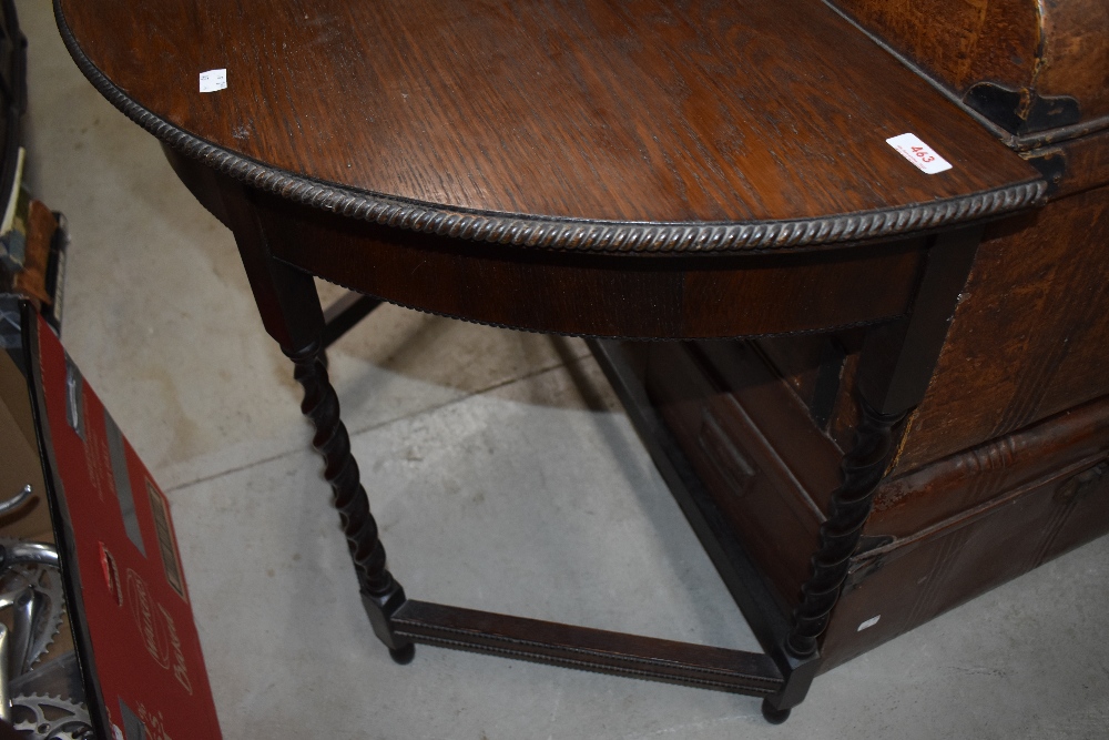 An early 20th Century oak demi lune side table having twist frame