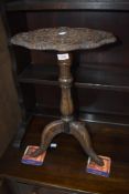 An interesting occasional table/candle stand having extensive carving throughout on triple splay