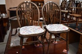 A pair of traditional dark stained wheelback kitchen chairs