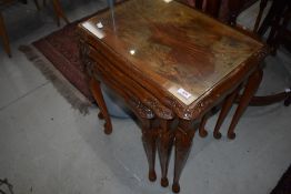 An early to mid 20th century walnut nest of three tables