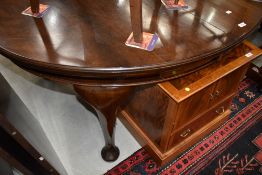 An early 20th Century mahogany oval dining table having wind out extensions with two further leaves,