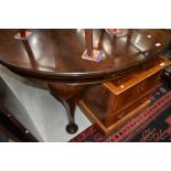 An early 20th Century mahogany oval dining table having wind out extensions with two further leaves,